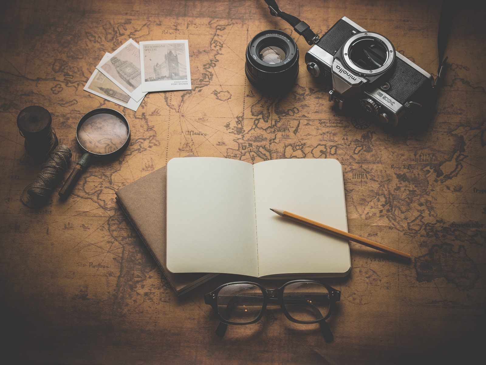 Foto von Dariusz Sankowski flat ray photography of book, pencil, camera, and with lens